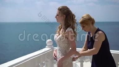 伴娘<strong>蕾丝礼服</strong>新娘在露台上。海上婚礼。